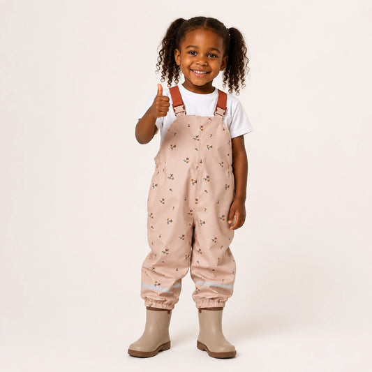 Salopette de pluie enfant beige rose a fleurs - portee par une fille
